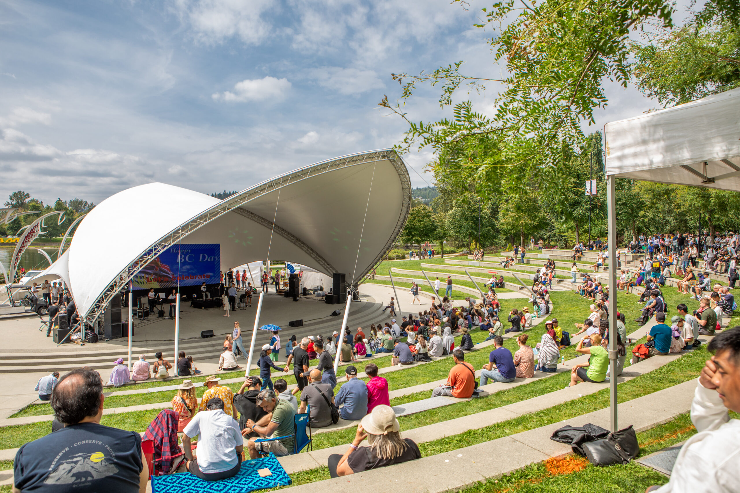 celebrate bc 2025 bandshell tina louise harris scaled Celebrate BC Day With Coquitlam's Wild Salmon Barbecue and Corgi Races This August 3 Crowd gathered at the Town Centre Park bandshell for a past Celebrate BC festival