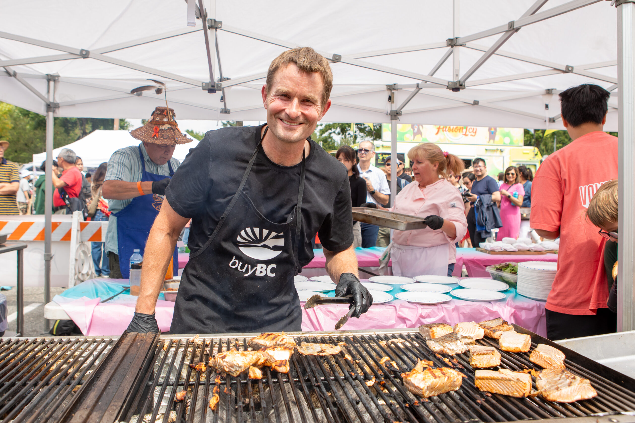 celebrate bc wild salmon bbq tina louise harris scaled Celebrate BC Day With Coquitlam's Wild Salmon Barbecue and Corgi Races This August 3 A cook grilling salmon fillets for the Celebrate BC wild salmon barbecue, Photography Credit Tina-Louise Harris