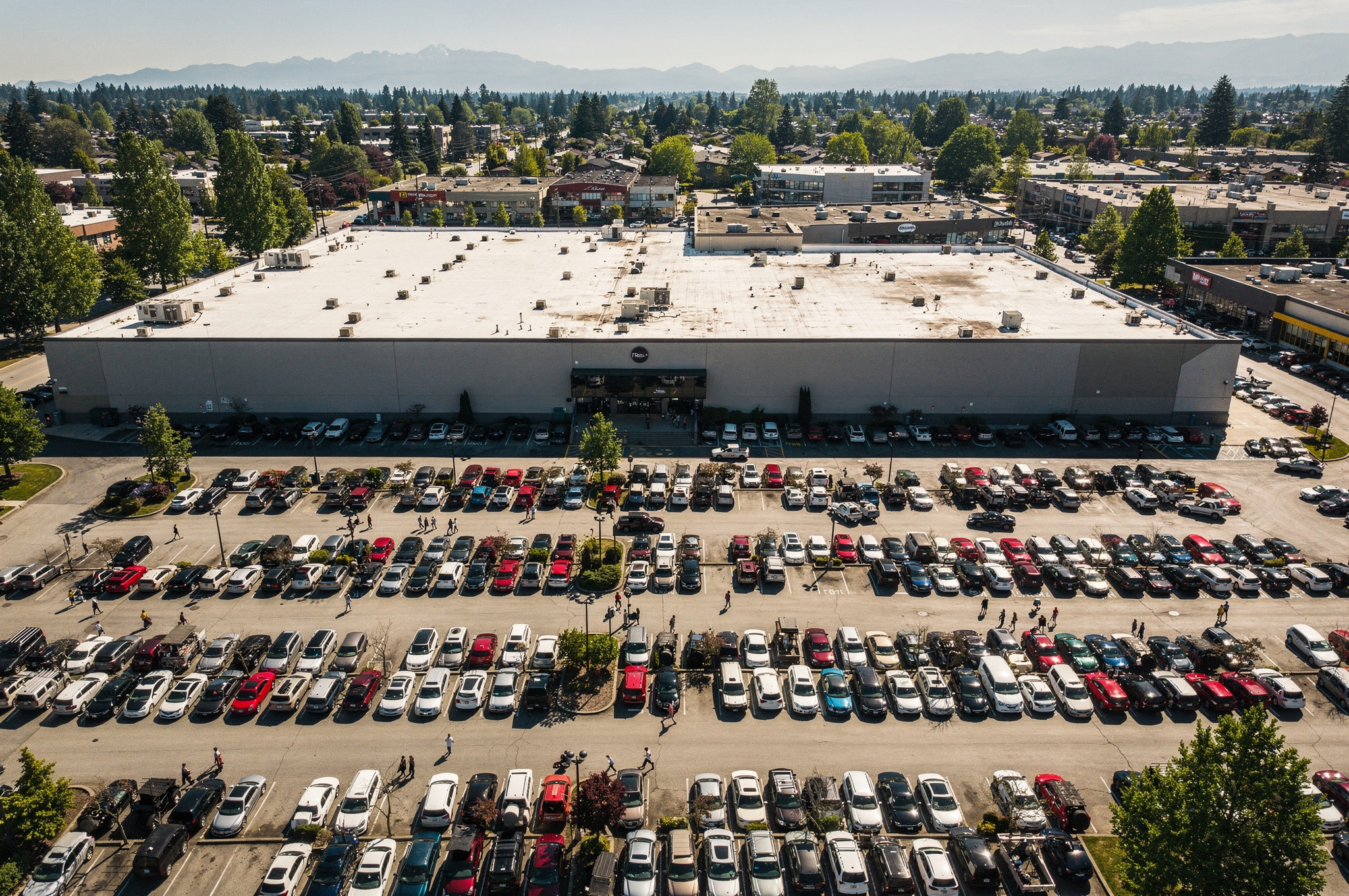 aerial view of a Coquitlam shopping centre parking lot with shoppers walking between rows of cars